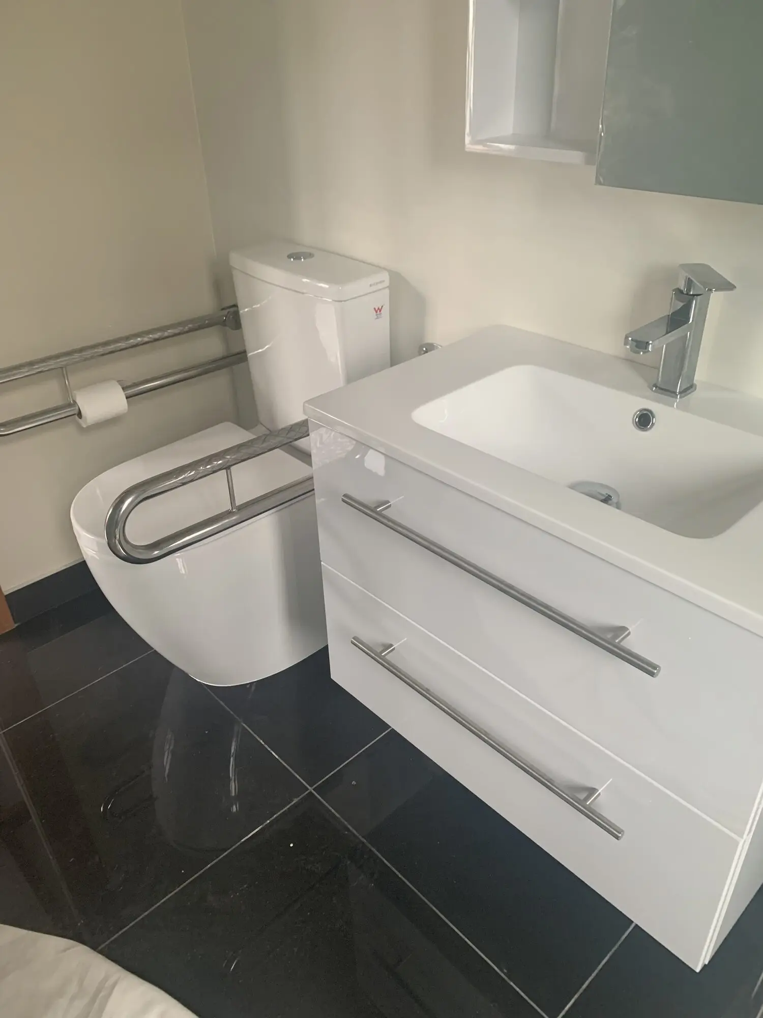 Accessible bathroom we fitted out with a wall-hung vanity and grab rail