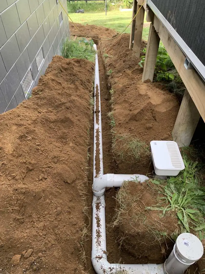 New drainage laid in a trench beside a relocated house